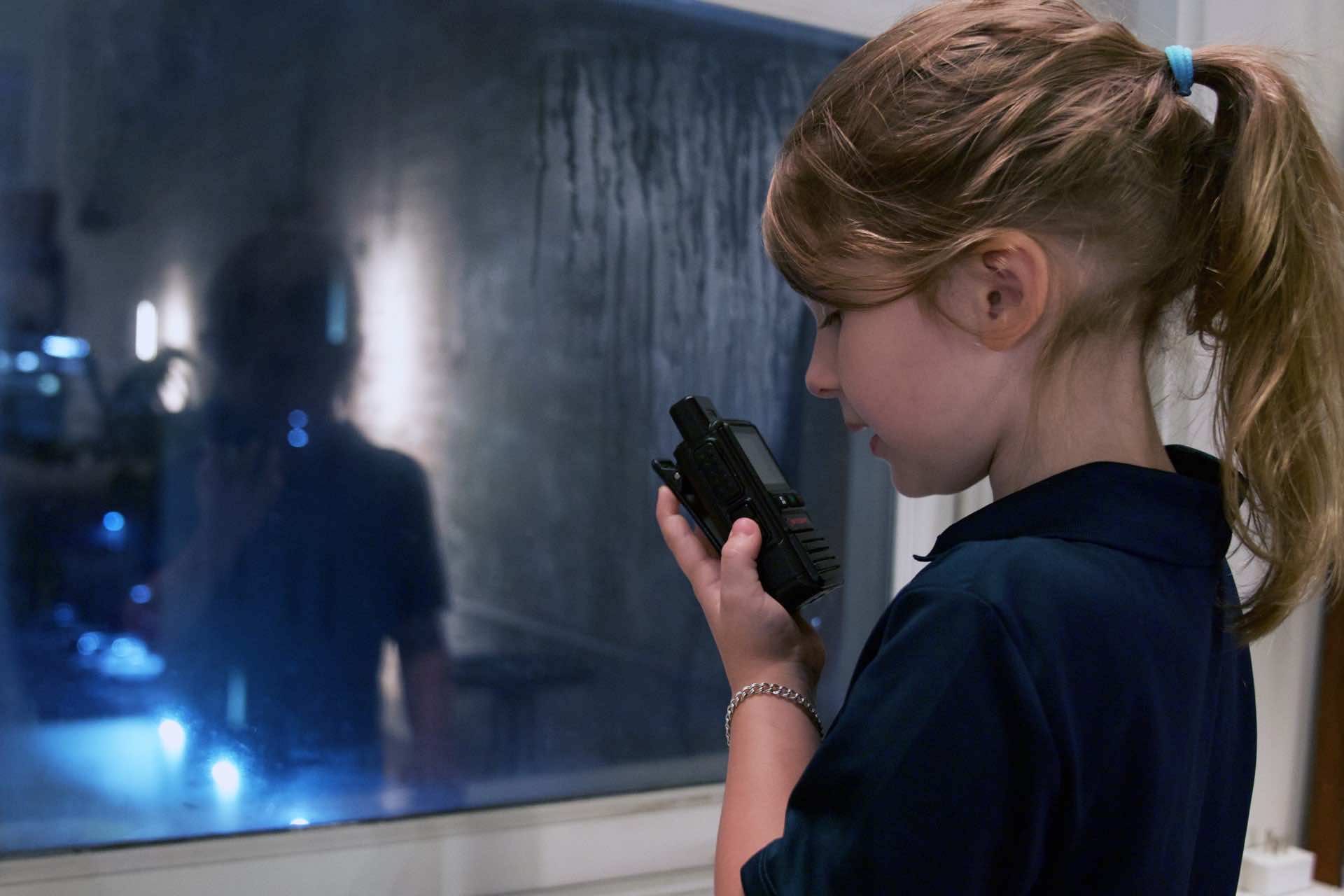 Young girl keying a SkyCom PTT radio at home